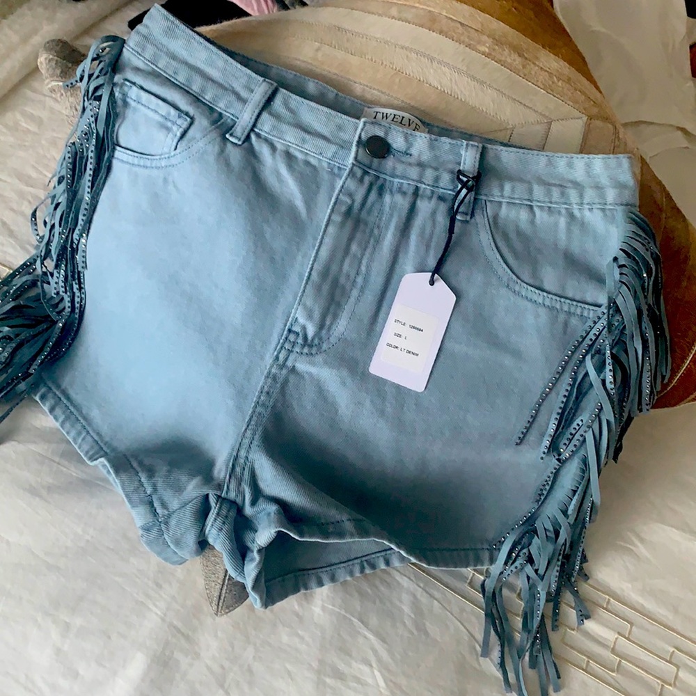 Denim jean shorts with fringe detail.